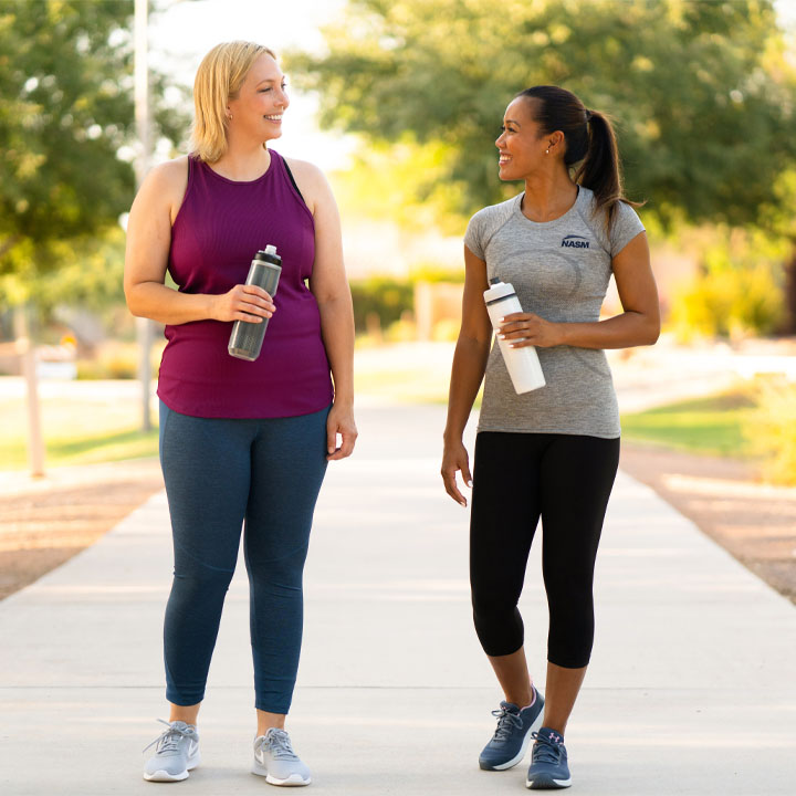two females walking on the sidewalk
