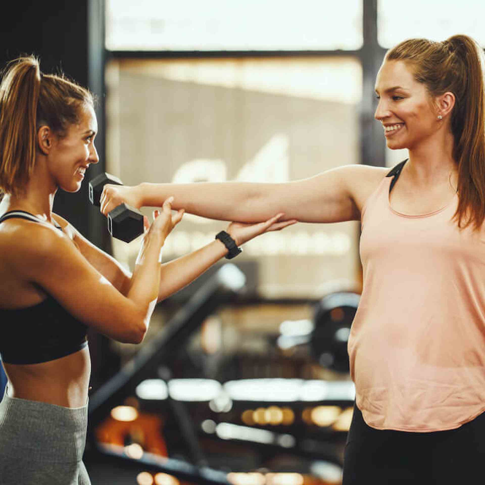 A female Women's fitness specialist training a female client