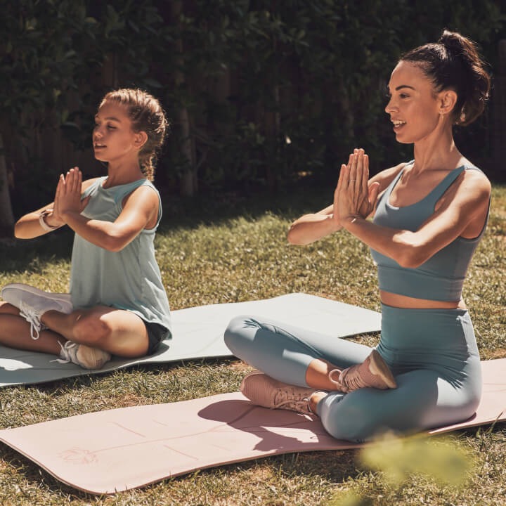 A woman and little girl meditating outside