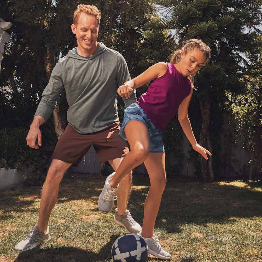 Father and daughter playing soccer in their backyard
