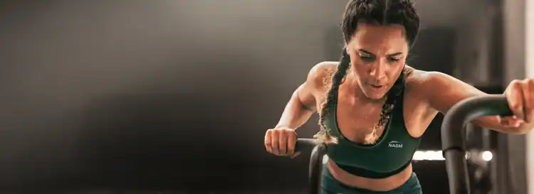 Female NASM Trainer using the stationary bike