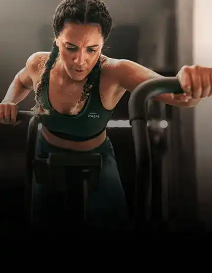 Female NASM Trainer using the stationary bike