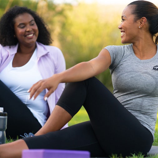 two women stretching in the grass