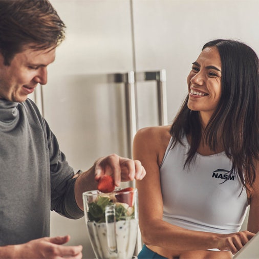 a man and a woman making a shake