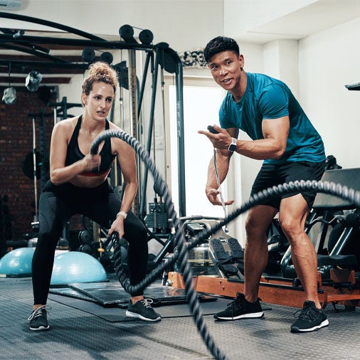a man training a woman on the ropes