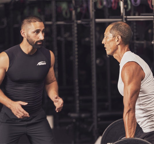 A male trainer helping a male client