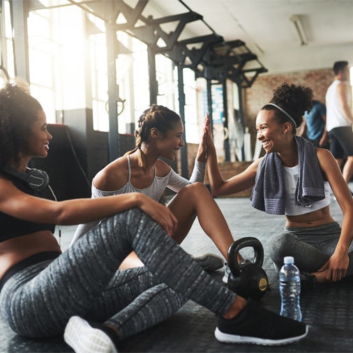 a group of women sitting on the floor laughing