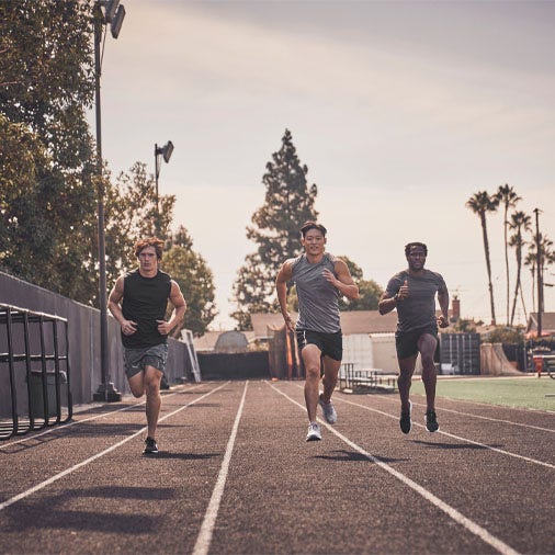male athletes running on a track outdoors