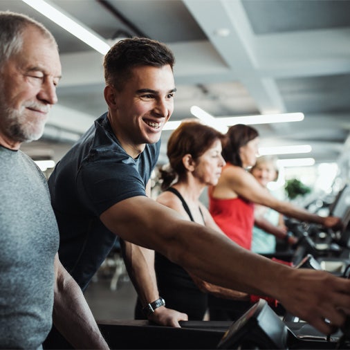 a male trainer showing a male client a treadmill