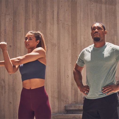 Women stretching arm and man standing beside looking away