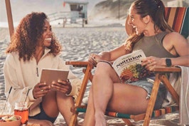 Two women chat on the beach