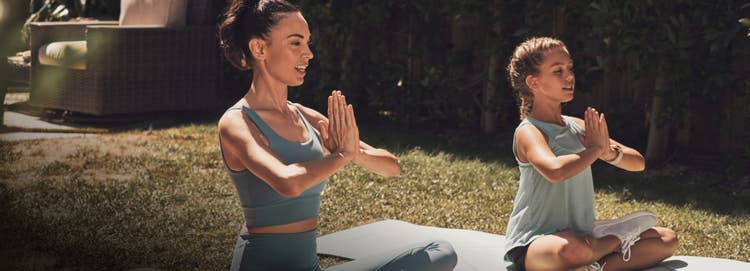 A woman and a young gitl doing Yoga