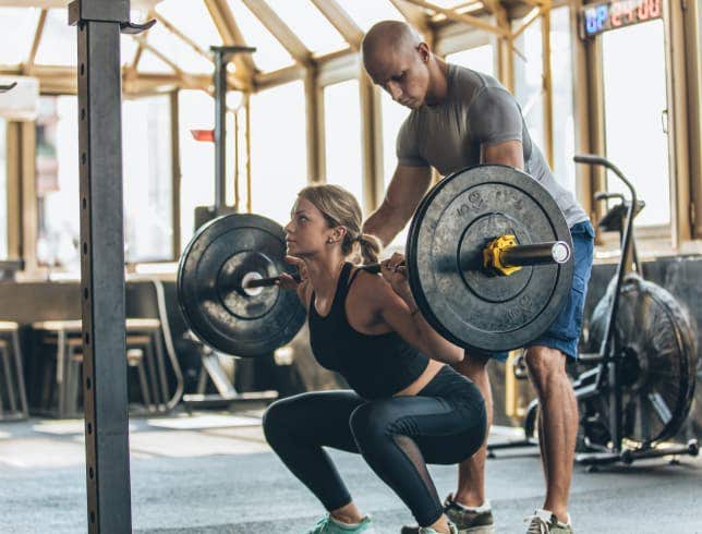 Trainer assisting with 1 rep