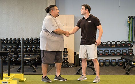 personal trainer and client shaking hands